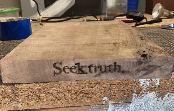 close up of wood burned shelf with text, "Seek truth."